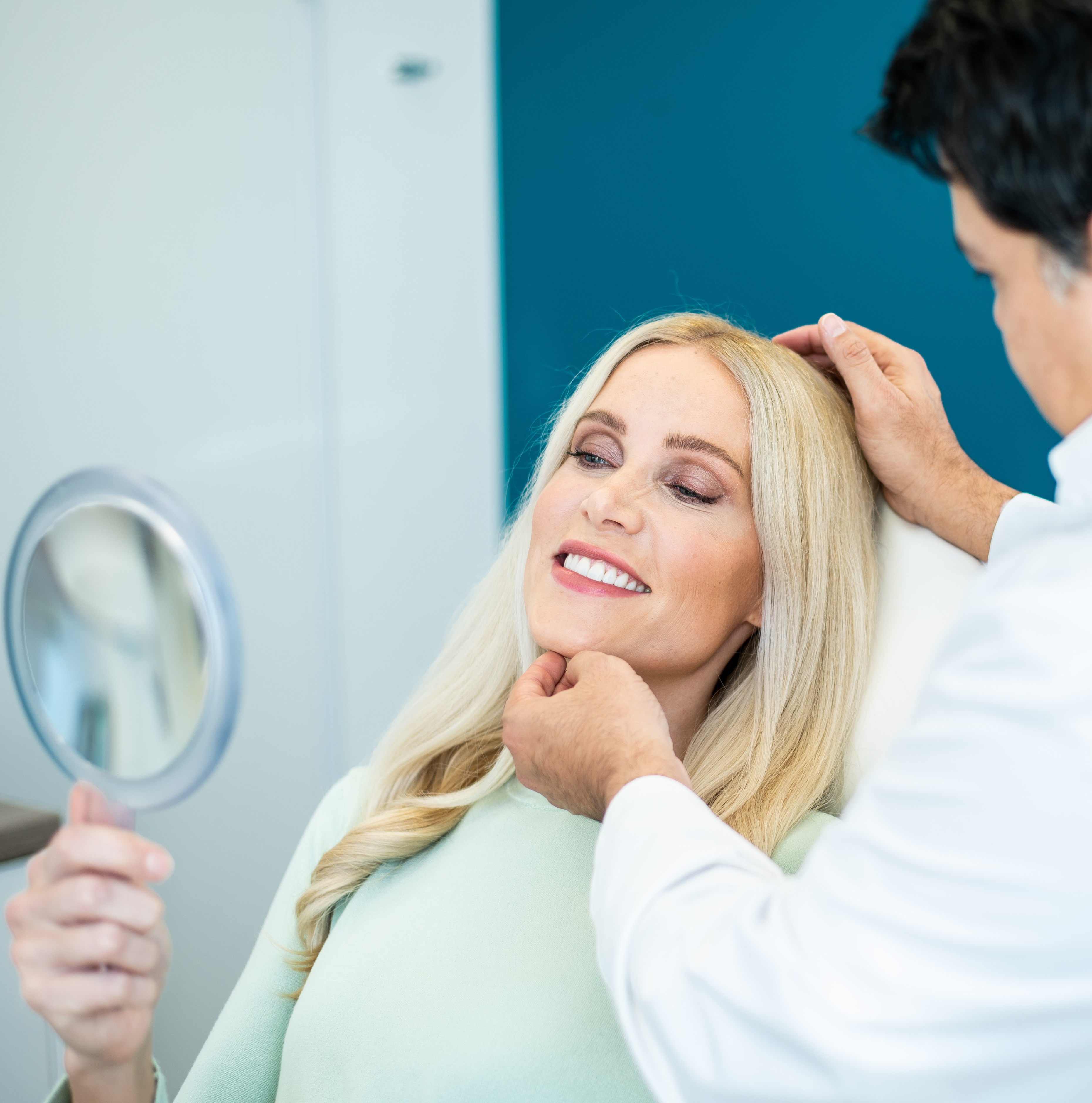 Eine blonde Patientin wird vom Arzt über den positiven Verlauf der Behandlung informiert.