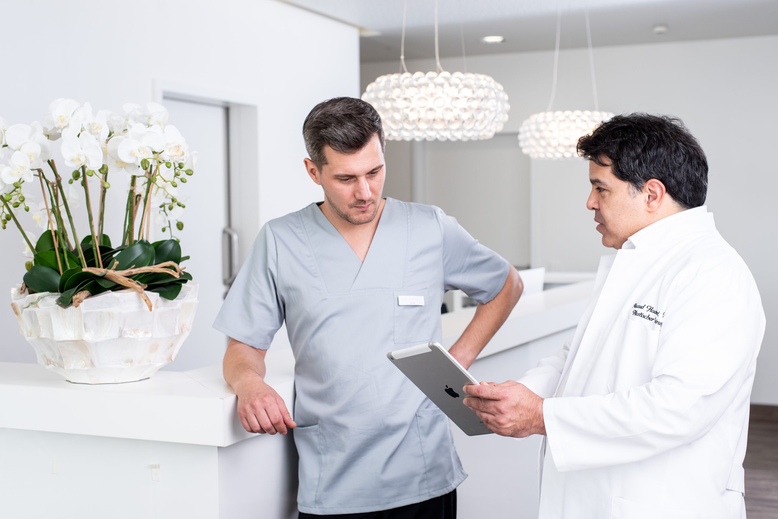 Der Arzt erläutert dem Pfleger die nächsten Schritte in der Behandlung des Patienten.