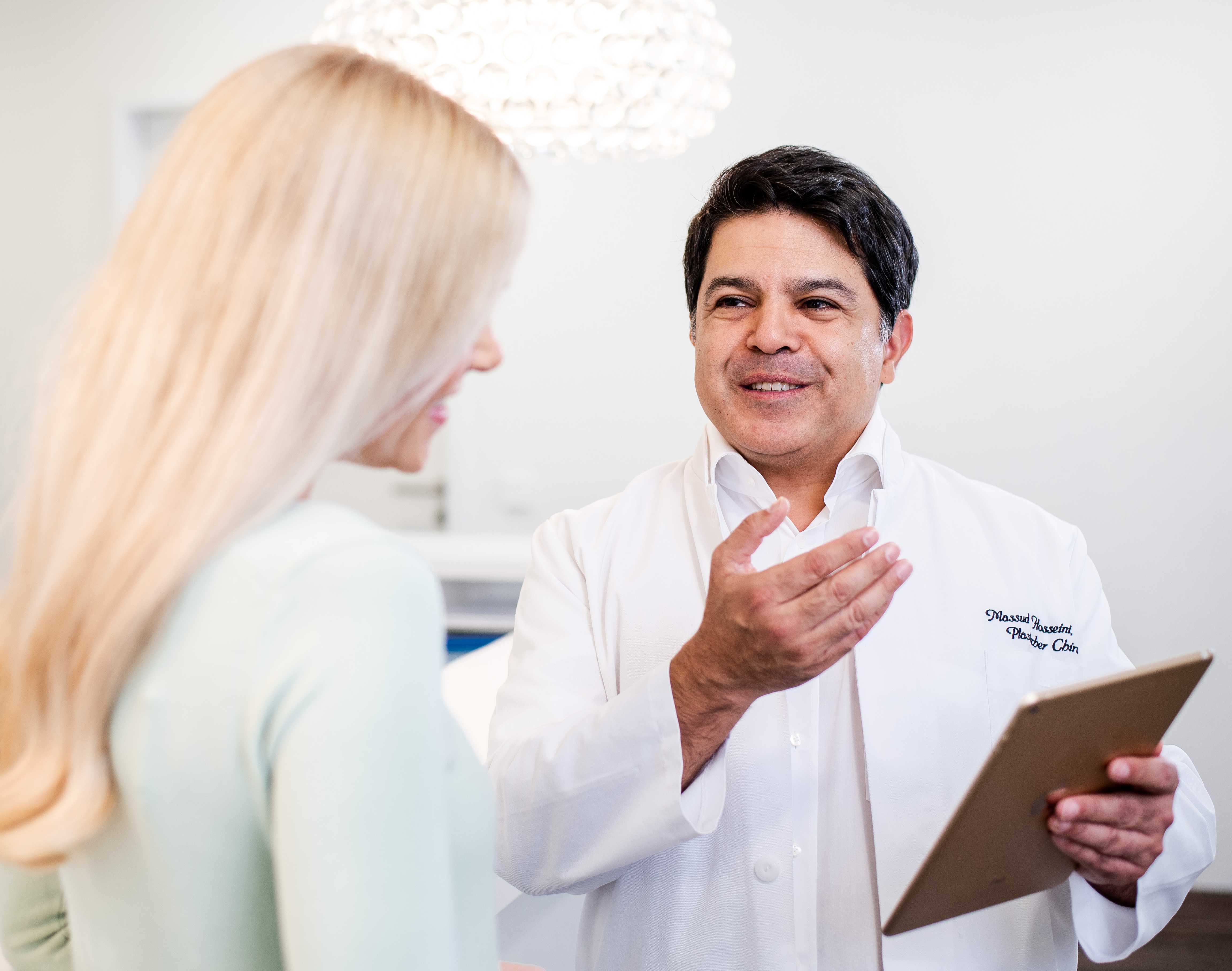 Ein Arzt erläutert einer blonden Patientin die weiteren Optionen für die Behandlung.