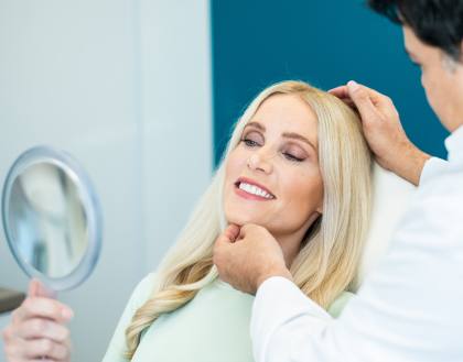 Eine blonde Patientin wird vom Arzt über den positiven Verlauf der Behandlung informiert