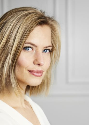 Schöne, dunkelblonde Frau, zufrieden, nach einer Gesichtsbehandlung.