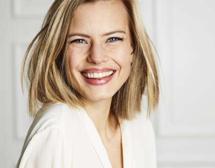 Schöne, dunkelblonde Frau, glücklich und zufrieden, nach einer Gesichtsbehandlung.
