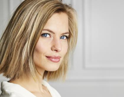 Schöne, dunkelblonde Frau, zufrieden, nach einer Gesichtsbehandlung.