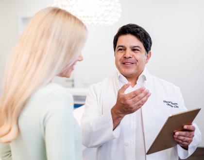 Ein Arzt erläutert einer blonden Patientin die weiteren Optionen für die Behandlung
